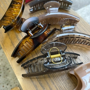 Close-up of assorted French hair claws in tortoise shell and cream on a wooden base