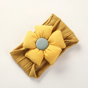 Detailed close-up of soft yellow nylon headband with large 3D flower and center button