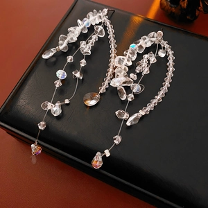 Detailed view of silver crystal tassel earrings on premium black leather gift box