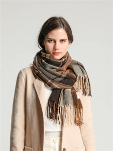 Detail of classic brown and beige plaid pattern scarf with soft fringe and knit texture