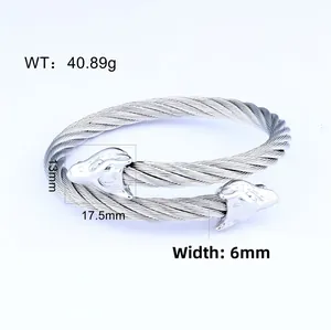 Detailed macro view of a 6mm stainless steel cable bracelet with carved wolf heads