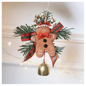 Detail of Christmas gingerbread man ornament with pine branches and a golden bell