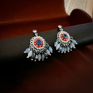 Bohemian floral tassel earrings with multicolored rhinestones and teardrop beads on a display