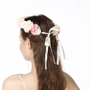 Detailed back view of pink and white floral crown with ribbon on model's hair