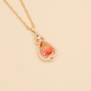 Golden necklace with a pear-shaped orange gradient gem and sparkling small zircons