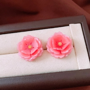Detail of pink resin flower earrings with layered petals and gold center in a display box