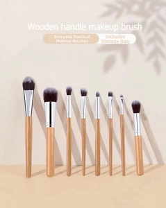 Close-up of 8-piece wooden handle makeup brushes with soft synthetic fibers on beige background