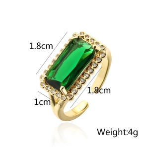 Macro view of geometric gold ring with rectangle emerald zircon and crystal halo detail