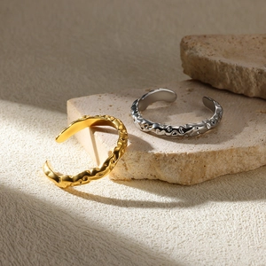 Detail of irregular gold and silver pearl flower rings on textured stone base