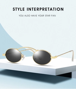 Detail view of oval retro sunglasses with gold metal frame on a geometric platform