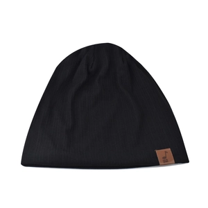 Detail of black ribbed knit beanie featuring a brown leather patch with music note icon