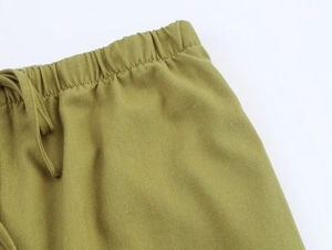 Close-up of linen trousers waist featuring elastic waistband and adjustable drawstring