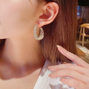 Élégantes créoles en C dorées avec micro-strass portées par un mannequin féminin