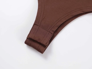 Close-up of the snap button closure and reinforced stitching on a brown cotton bodysuit