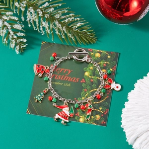 Christmas charm bracelet with Santa, reindeer and tree pendants on festive green background