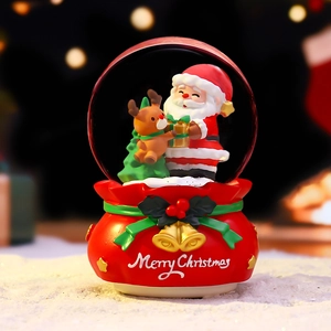 Christmas snow globe featuring Santa and reindeer figures on a festive red base