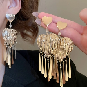 Detail of crinkled heart earrings with long metallic tassels and crystal inlay