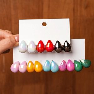 Close-up of ten pairs of colorful teardrop earrings on a white display card