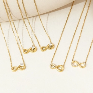 Elegant gold infinity pendant necklace set with zirconia stones on a minimalist background