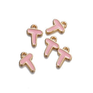 Detail view of five pink enamel and gold-plated letter T charms for DIY jewelry making