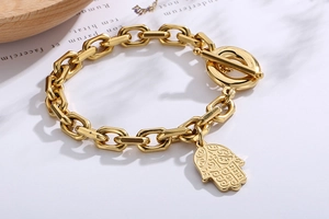 Detail view of the golden Hamsa hand pendant and toggle clasp on a chunky link chain