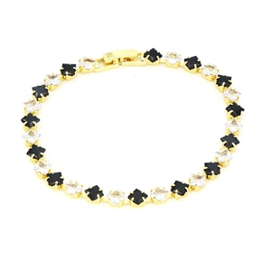 Detail of 18k gold tennis bracelet featuring black and white clover zircons and lobster clasp