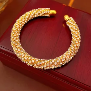 Elegant gold-plated open bangle featuring sparkling pavé zircon stones on a wooden jewelry box