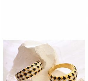 Close-up of gold-plated rings with black and white checkerboard enamel pattern