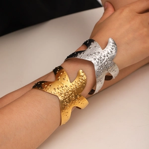 Hammered starfish cuff bracelet in gold and silver finish on model's wrist