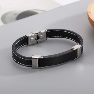 Macro detail of men's leather bracelet with white contrast stitching and steel clasp