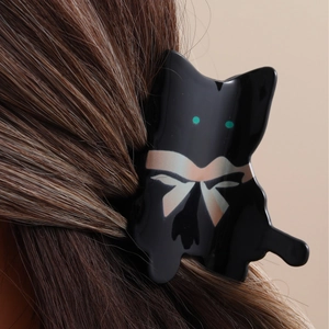 Cute black cat acetate hair claw clip with bow pattern shown worn on hair for styling