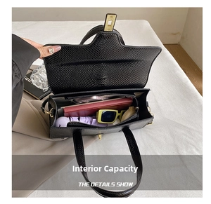 Detail view showing large interior capacity of black reptile texture tote bag with golden lock