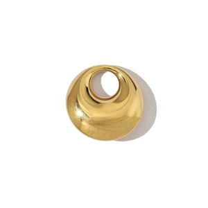 Macro d'un pendentif rond concave doré avec trou central sur fond blanc épuré