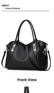 Detail of black faux leather handbag with crocodile texture and gold hardware