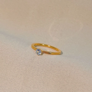 Minimalistischer Ring aus Gold-Titanstahl mit rundem Zirkon und eleganter Sechskant-Fassung