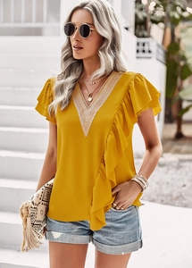 Close-up of yellow V-neck top featuring lace patchwork and feminine ruffled sleeves details