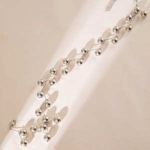 Detailed view of chunky silver bead necklace with wave design and lobster clasp closure