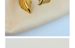 Macro detail of 18K gold plated stainless steel stud earrings with textured leaf pattern