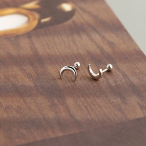 Dettaglio macro di orecchini a mezzaluna in argento sterling con chiusura a vite