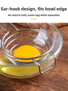 Spiral stainless steel egg white separator filtering liquid over glass bowl
