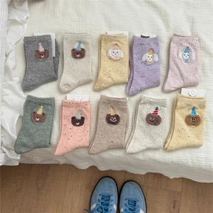 Detailed close-up of mixed color speckled socks with cute embroidered cartoon animal icons
