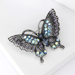 Macro shot of retro silver butterfly brooch with colorful crystals and hollowed wings