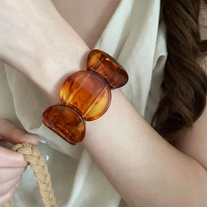 Detailed view of an amber acrylic bangle bracelet with vintage modular geometric pattern