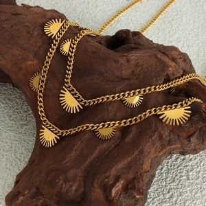 Chic 18K gold plated titanium steel necklace with celestial sun pendants on a wood stand