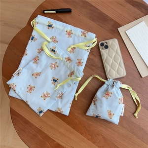 Three sizes of blue striped cotton drawstring bags with cute bear prints on wooden table