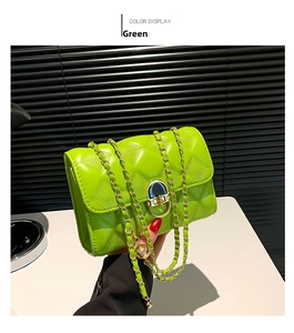 Detail of green quilted crossbody bag with gold chain strap and metallic lock closure