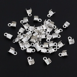 Detailed close-up of silver metal ribbon crimps with textured teeth for DIY jewelry making
