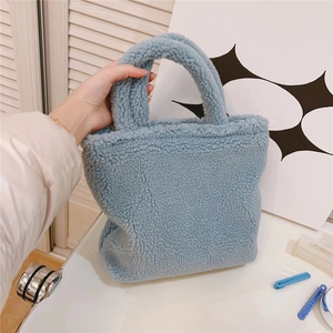 Vista dettagliata della borsa tote in peluche blu con consistenza morbida e manico spesso