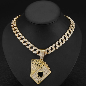 Détail macro du pendentif poker royal flush avec une épaisse chaîne cubaine dorée