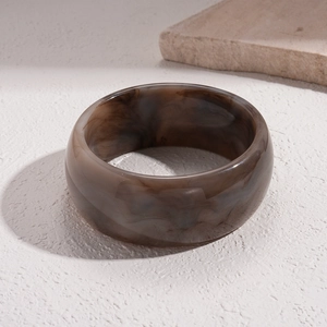 Detail shot of wide brown marble acrylic resin bangle with smooth polished finish